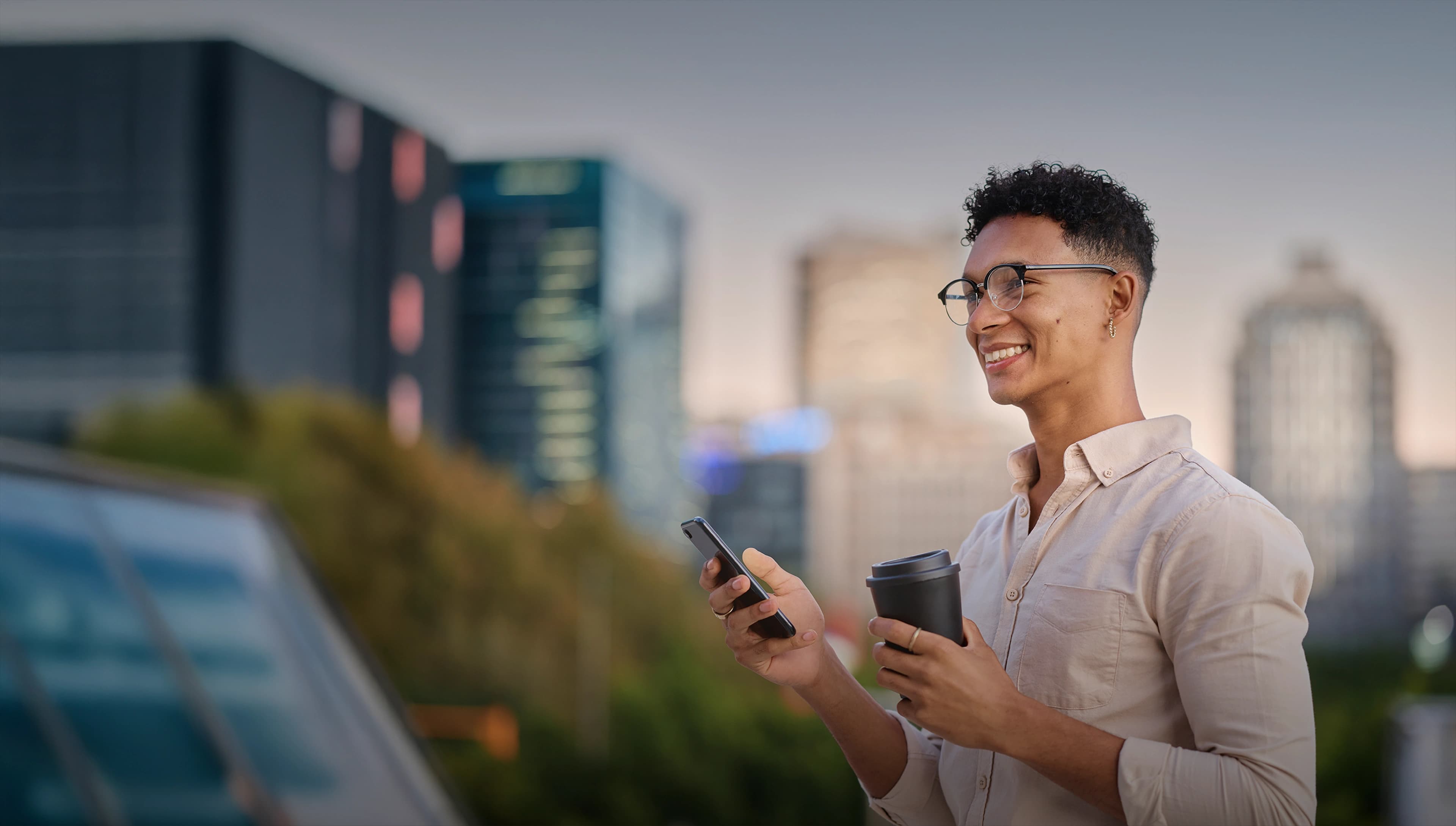 Professional man with phone and coffee in urban setting